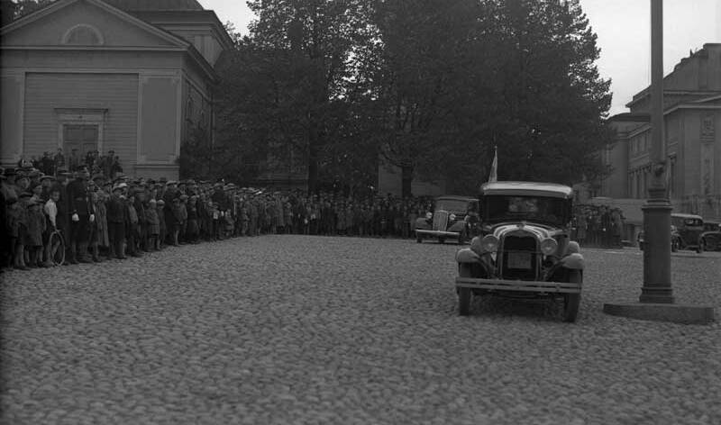 Valtava ihmisjoukka on pakkaantunut Vanhan kirkon eteen ja Keskustorin puoleiselle seinälle katsomaan mukulakivillä ajavaa autoa.
