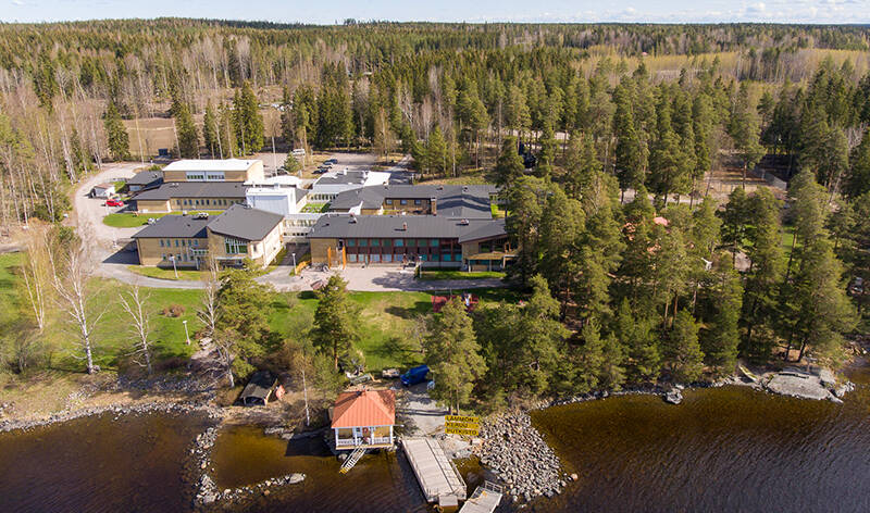 Ilmakuva AitO-keskuksesta paljastaa, kuinka suuri keskuksen päärakennus on. Alueella oleva huvila, Virkkula, on puiden kätkössä. Etualalla näkyy Virkkulan rantasauna ja laituri.