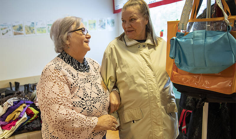 Diakoniapäivään saapunut Anneli Laine sovittelee takkia kierrätyspäällikkö Hilkka Branderin avustamana.