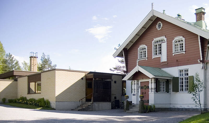 Vanha koristeellinen ja uudempi pelkistetty rakennus vierekkäin ulkona.