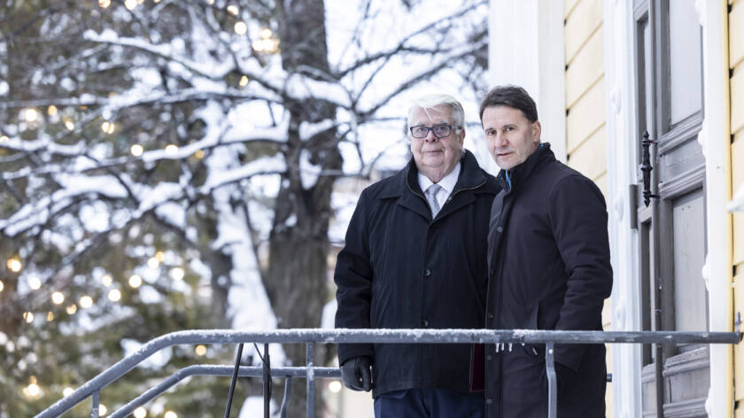Kalervo Kummola ja Olli-Pekka Silfverhuth Vanhan kirkon portailla, taustalla luminen valaistu puu.