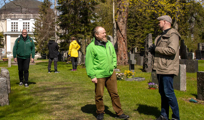 Hautausmaalla, joka on alkukesän vihreä päivystäjät Jussi Holopainen ja Ville Aalo keskustelevat kuvassa oikealla. Teemu Salminen kävelee kappelilta kasvot kameraa kohti.