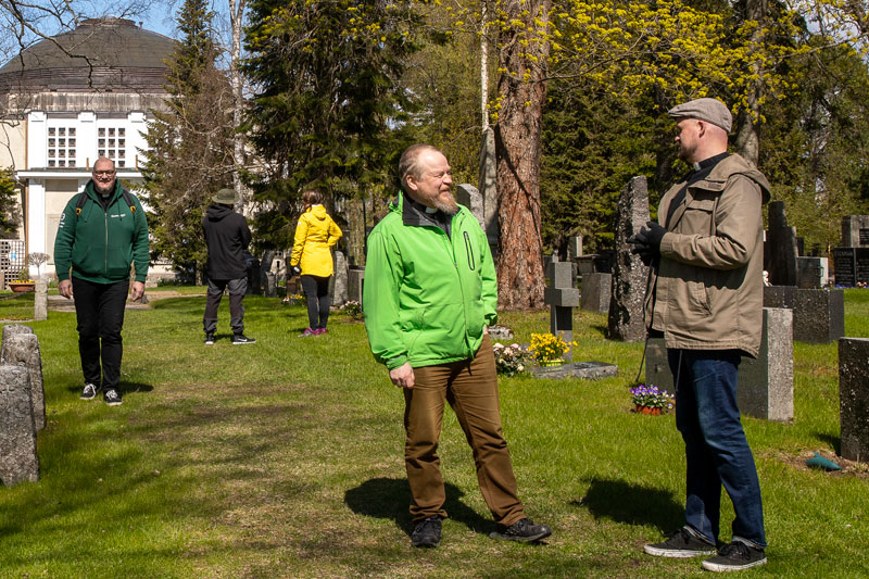 Hautausmaalla, joka on alkukesän vihreä päivystäjät Jussi Holopainen ja Ville Aalo keskustelevat kuvassa oikealla. Teemu Salminen kävelee kappelilta kasvot kameraa kohti.