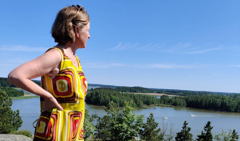 Nainen katsoo kohti merta.