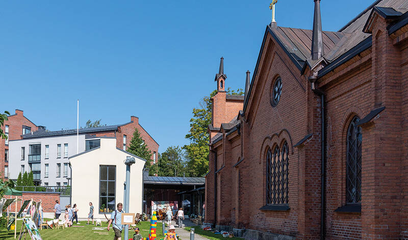 Finlaysonin kirkon pihalla ihmisiä ja leluja kesäpäivänä.
