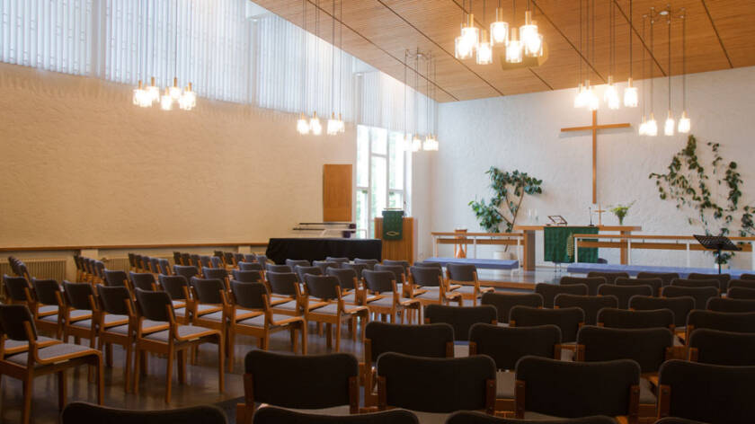 Lielahden kirkon salissa on irtopenkkirivit, suora alttari kaide ja suuria ikkunoita.