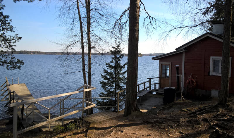 Pieni saunarakennus järvenrannassa.