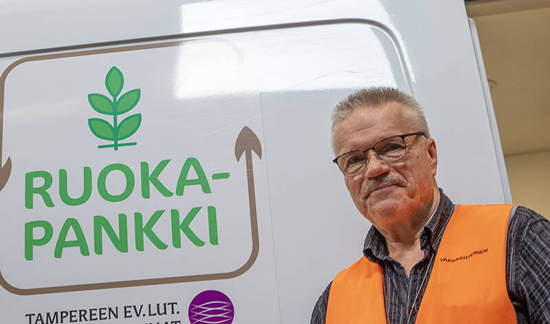 Esa Matikainen kantaa ruokalaatikkoa autoon.