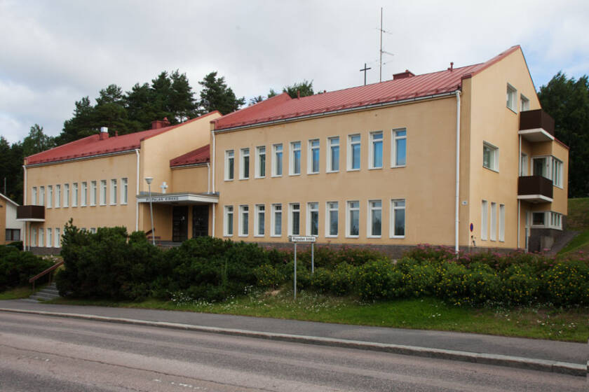 Pispalan valtatien varrella olevaan kirkkoon käydään keltaisen, harjakatotoisen seurakuntatalon läpi.