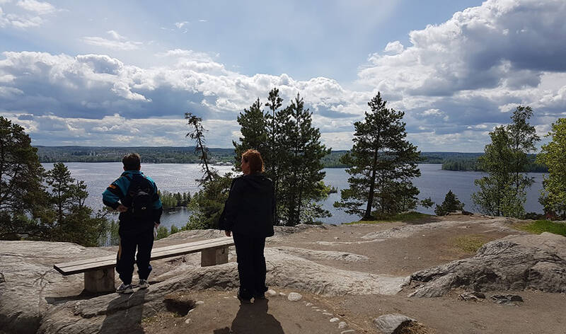 Kaksi ihmistä seisovat Pyynikin näköalapaikalla ihailemassa maisemia.