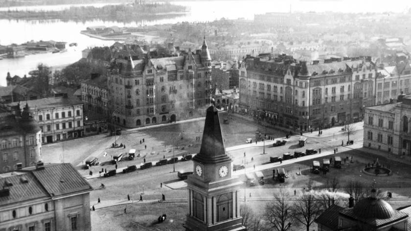 Mustavalkoinen ilmasta otettu kuva vuoden 1933 Tampereen keskustasta. Keskellä kirkon torni ja ympärillä kivitaloja.