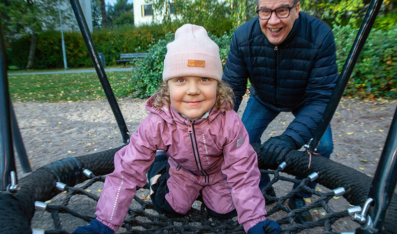 Timo Saarinen antaa keinuvalle lapselleen vauhtia.
