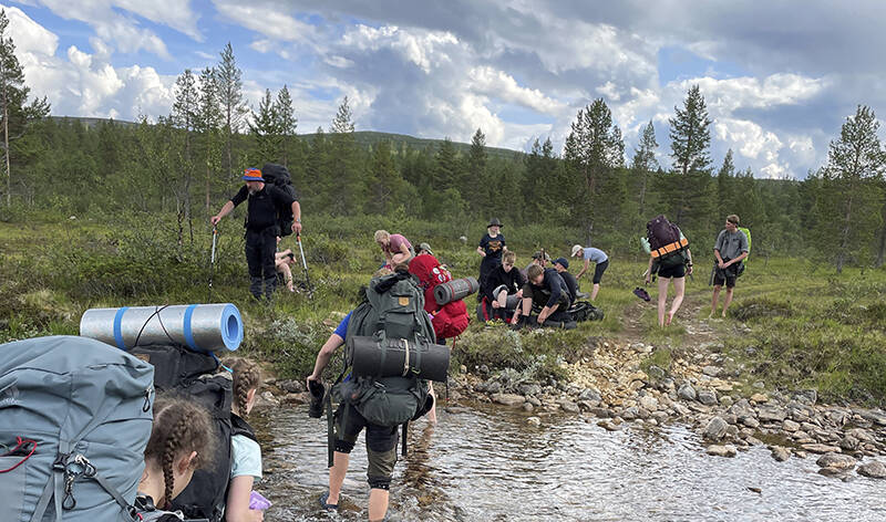 Vaellsurippikoululaiset ylittävät puroa.