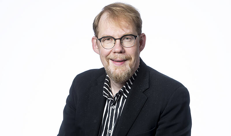 Ylävartalokuva miehestä puku päällä.