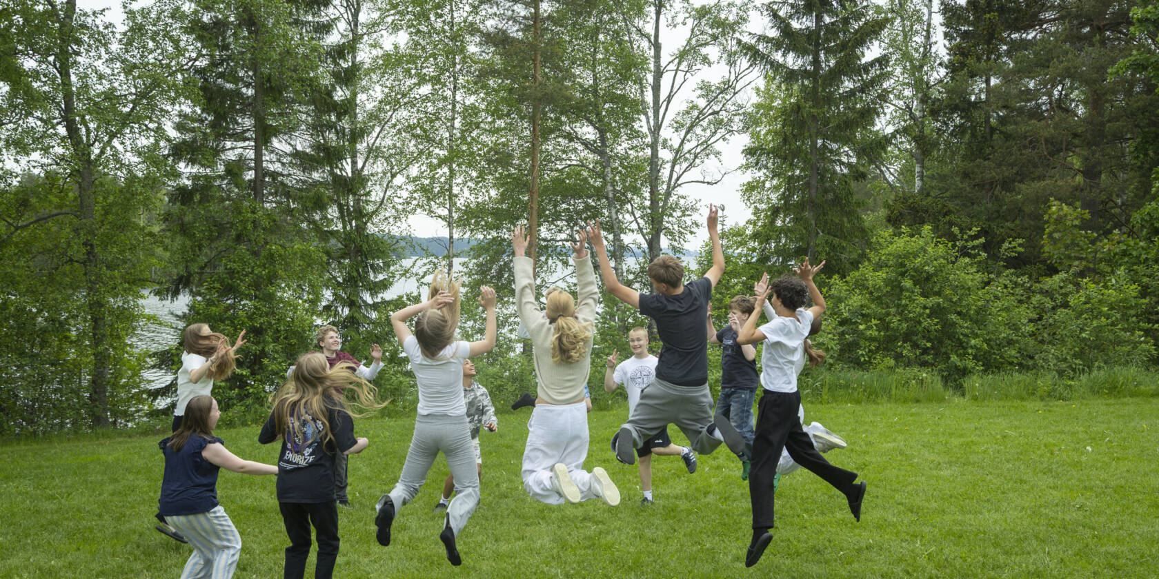 Nuoria hyppäämässä ilmaan nurmikolla.
