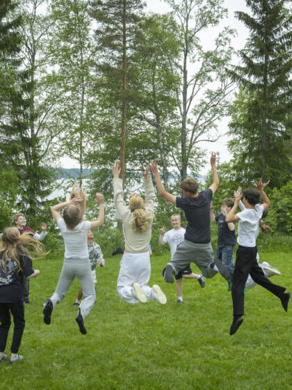 Nuoria hyppäämässä ilmaan nurmikolla.