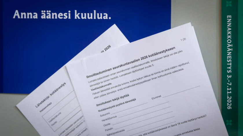 Seurakuntavaalien mainoksen edessä paperi, jolla voi ilmoittautua kotiäänestykseen.