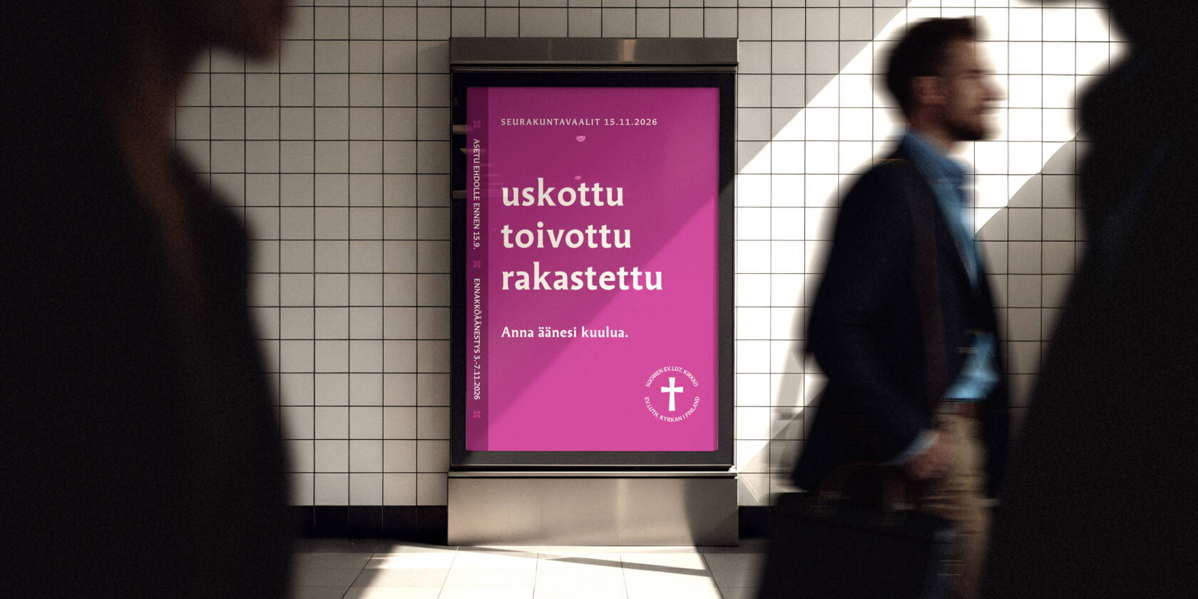 Seurakuntavaalien katumainos metrotunnelissa, jossa kulkee ihmisiä.
