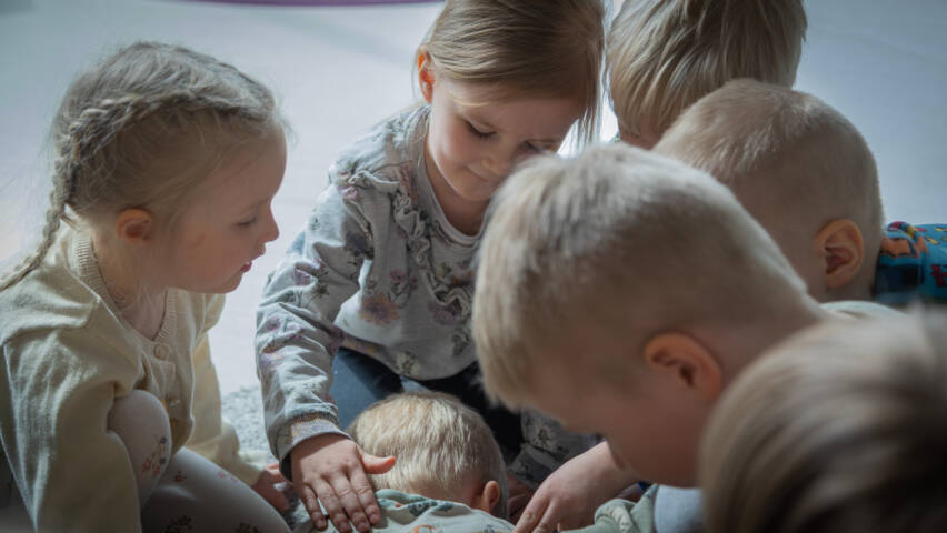 Lapsia yhden lapsen yhden ympärillä, ja he silittävät lapsen selkää.