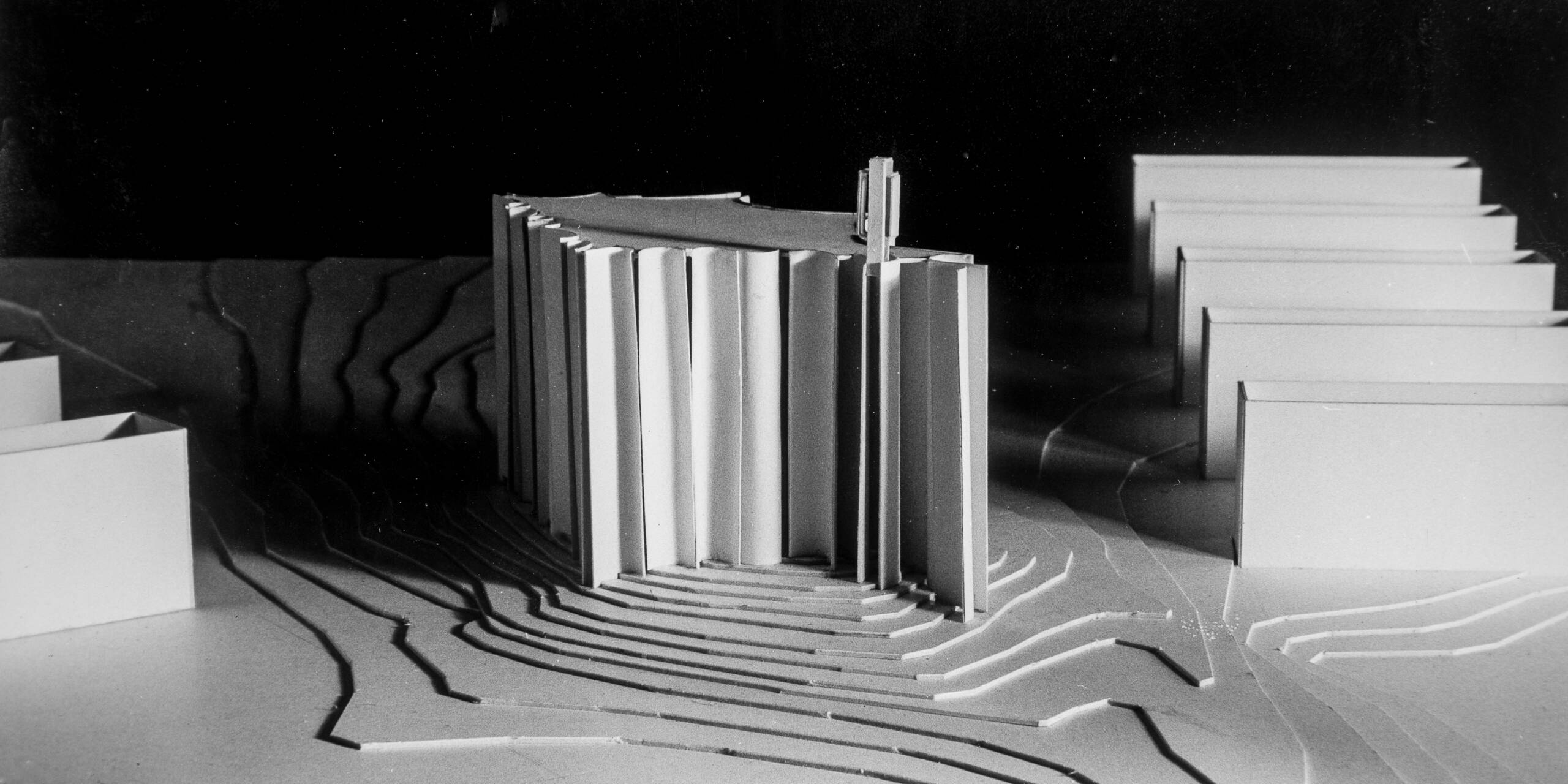 Scale model of the winning design for Kaleva Church. The tall, fan-shaped church rises in the centre, surrounded by modelled terrain and apartment blocks.