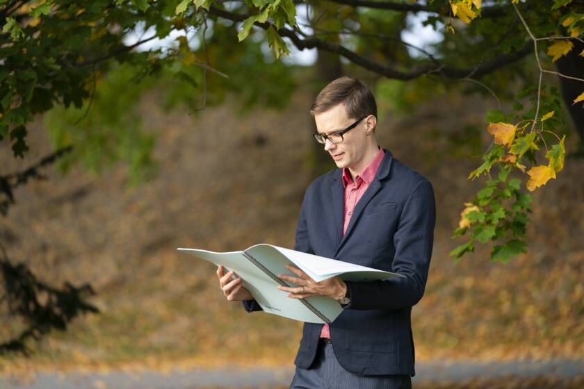 Ilkka Hammo syksyisessä luonnossa suuri lehtiö käsissään.