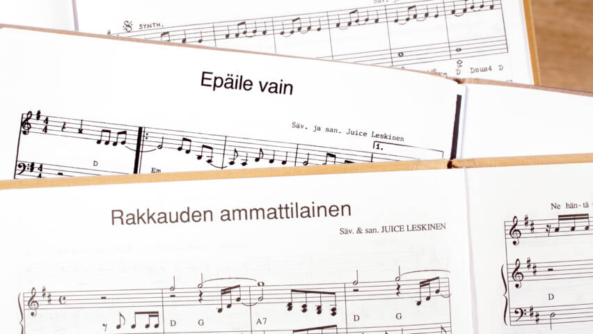 Musiikkilehtiä, jossa näkyy nuotteja ja sanoituksia kahdesta eri kappaleesta.
