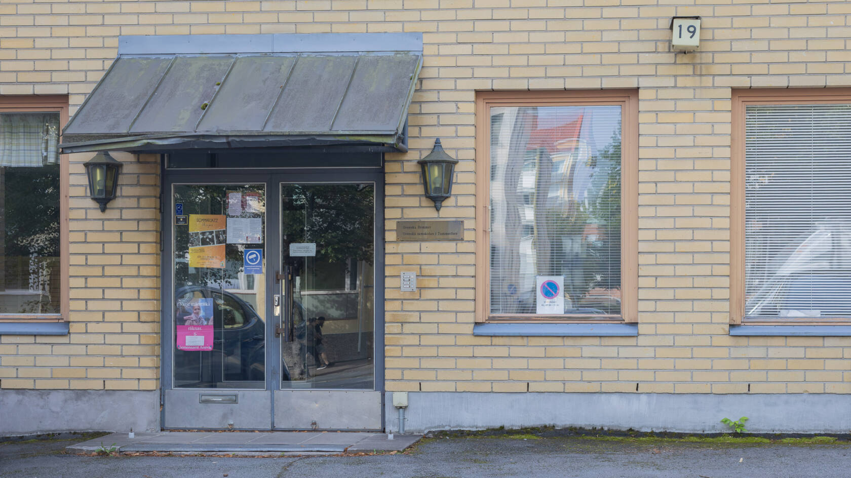 Svenska Hemmetin ja Svenska samskolan i Tammerforsin sisäänkäynti vaaleankeltaisessa tiilirakennuksessa.