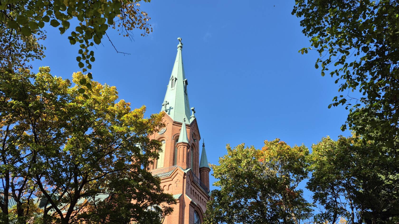 Puiden välistä näkyy Aleksanterin kirkon torni.
