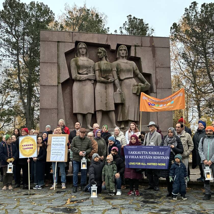Ihmisiä syksyisessä säässä kookkaan muistomerkin edustalla.